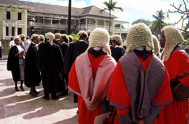  A group of male and female judges and lawyers, wearing traditional Bahamian court attire, gather outside a building. --- Image by © Kit Kittle/CORBIS