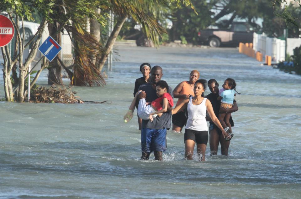 A family in West Grove had to be rescued as their home flooded with water in the aftermath of Hurricane Sandy. Bahamas Press warned Bahamians in low areas to make their way to Hurricane Shelters and avoid being trapped in flood zones.