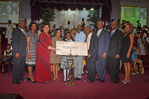 Members of the Board of Directors, The Bahamas Primary School Student of the Year – Steven Strachan, Myra Mitchell, Ricardo Deveaux, Vandyke Pratt and CC LaFleur, Deborah Zonicle - RBC Royal Bank of Canada along with the Hon. Jerome Fitzgerald – Minister of Education, Science and Technology presenting Samiya Lundy with her award. Her parents – Mark and Shantell Lundy looks on. 