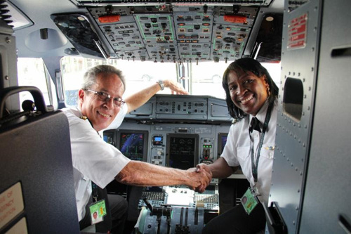 Captain Paul DaSilva (left) and First Officer Karen Tulloch in the flight deck at V.C. Bird International Airport.