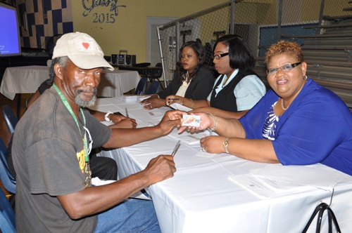 PREPAID CARD LAUNCHED - The Department of Social Services on Monday officially launched their Pre-Paid Debit Card system in Grand Bahama at the Eight Mile Rock High School Gymnasium. Shown is Clarence Wilchcombe receiving his card from Patrice Johnson, Department of Social Services. (BIS Photo/Vandyke Hepburn)