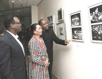 HE Governor General Dame Marguerite Pindling, Minister of Youth, Sports and Culture the Hon. Dr. Daniel Johnson, and Choir Director Cleophas Adderley view the historical display of photographs depicting the development of the Bahamas National Youth Choir over 25 years at its anniversary exhibit at the Central Bank of The Bahamas. 