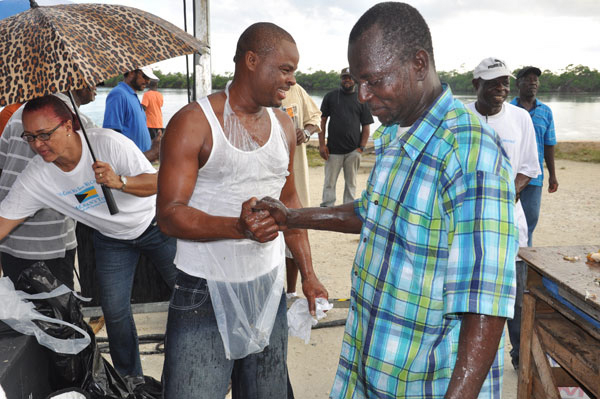 CONGRATULATIONS – Following a highly competitive conch cracking competition on Monday in McLean’s Town at the 43rd annual Conch Cracking Competition, Cardinal McIntosh (plaid shirt) is seen congratulating the winner, Joseph Tate. McIntosh, who placed third, was the winner in last year’s competition. (BIS Photo/Vandyke Hepburn)