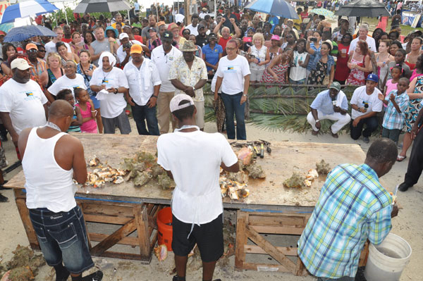JUDGING THE COMPETITION – Hundreds gathered around the table as the Conch Cracking Competition took place during the 43rd annual festival in McLean’s Town on Monday. Shown are Deputy Leader of the Official Opposition and Member of Parliament for East Grand Bahama, Peter Turnquest; Permanent Secretary for the Ministry of Tourism, Harrison Thompson; and former Member of Parliament for High Rock Constituency, Kenneth Russell, the three judges for the event. (BIS Photo/Vandyke Hepburn)