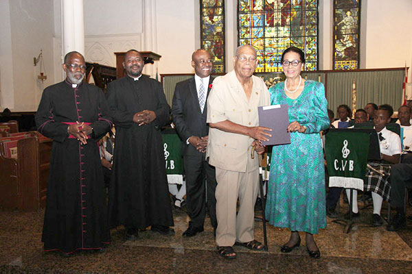 Certificate Presentation Photo shows Her Excellency Dame Marguerite Pindling, right, presenting certificate to Roosevelt Godet.  Minister of Tourism Obie Wilchcombe is centre; and the Dean Very Reverend Patrick Adderley and Fr. Humes.