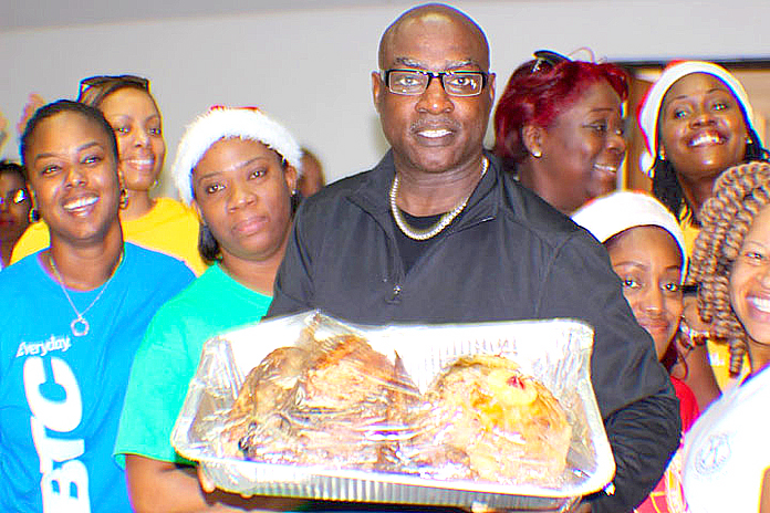 Chairman of the Kiwanis Give Love on Christmas Day Project, Barry Wilmott flanked by volunteers from the Bahamas Telecommunications Company.