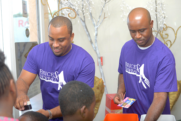 Hard at work: A Sure Win and Brice & Newball Foundation co-founders, Leander Brice and Garvin Newball hand out tickets to young party-goers. Pictured: Garvin Newball (L), Leander Brice (R) 