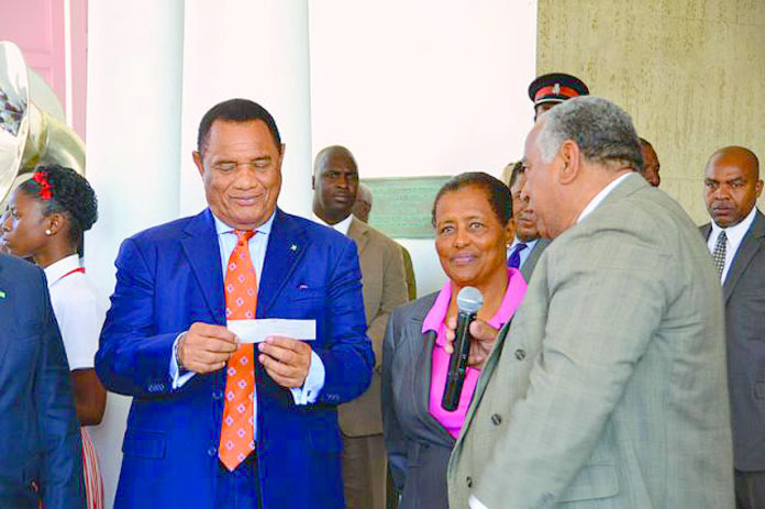 Prime Minister Christie receiving a $20,000 donation from the Wells family for work in the inner city in 2013.