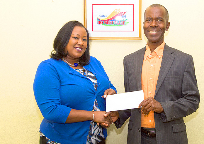 Christine King, General Manager at The Paint Place presents Philip Smith, Executive Director Bahamas National Feeding Network with a donation. (Photo by Cay Focus Photography.)  