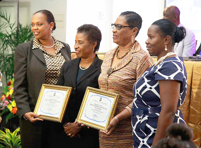 Dr. Pandora Johnson presents an award to the Early Childhood Care and Pre-School Section, MOEST, for its participation in the 2015 Commonwealth Good Practice Awards. 