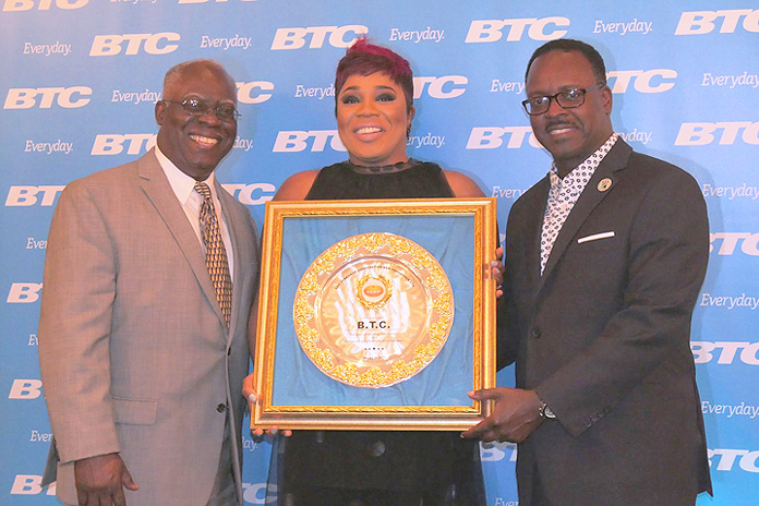JCNP President Silbert Ferguson and Minister of Youth, Sports and Culture Danny Johnson present BTC, represented by Vice President of Marketing Eldri Ferguson-Mackey, with an award for their exemplary support. 