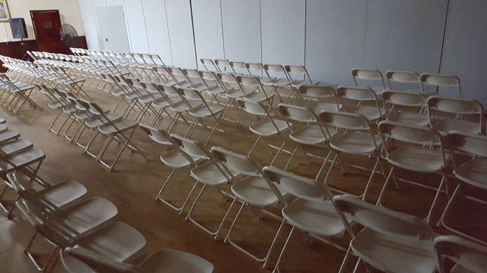 Plenty chairs in the room partitioned off after few persons showed up.