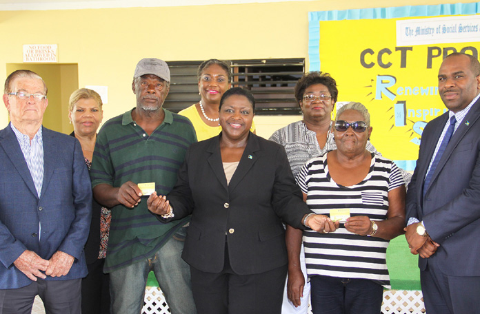 The Hon. Melanie Griffin, Minister of Social Services & Community Development presents the first Cash Transfer Cards to Alfred Woodside and Inez Fox, Monday, June 27, 2016.  (BIS photo/Patrick Hanna) 