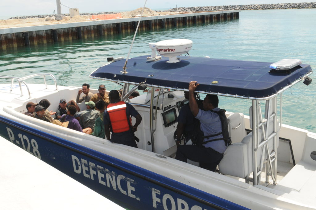 Defence Force patrol craft P-128 arriving at the Coral Harbour Base with 14 Cuban migrants. The migrants were transported to the Carmichael Road Detention Center. 