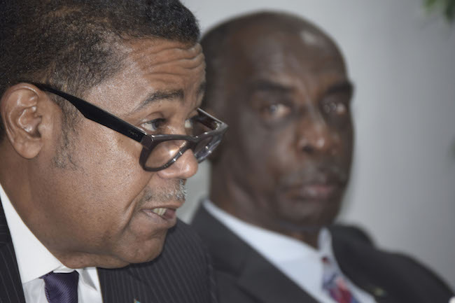 Minister of Health the Hon. Dr. Perry Gomez, left, addresses the press. Looking on is Ministry of Tourism Permanent Secretary Harrison Thompson, acting in the capacity of PS/Ministry of Health. (BIS Photo/Derek Smith) 