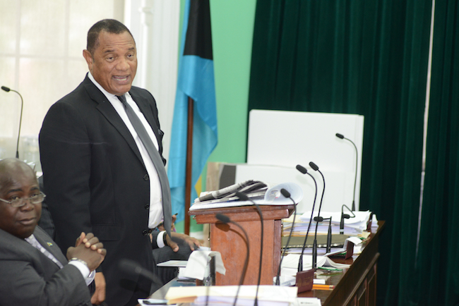 Prime Minister Perry Christie closing National Health Insurance debate in the House of Assembly on Monday, August 15, 2016. Deputy Prime Minister Philip Davis, seated, looks on. (BIS Photo/Peter Ramsay)