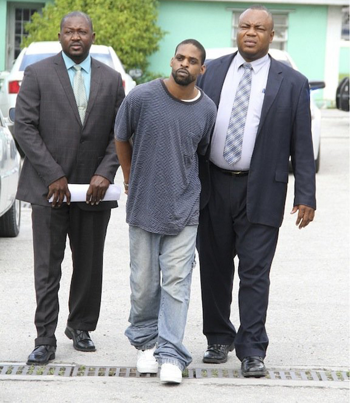 Lynden Prosper, who is accused alongside a 16-year-old of the murder of Dakeil Curry, is escorted into court yesterday. There was a heated argument outside the court between families of the victim and the accused. See story on page eight.Photo: Tim Clarke/Tribune Staff