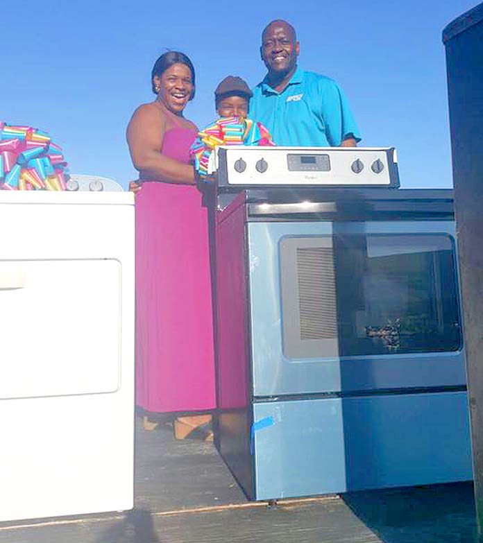 Ms. Ann Strachan is presented with a brand new stove courtesy of BTC.